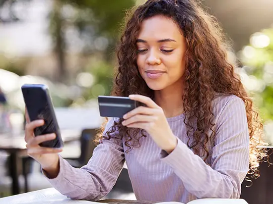 Image of a college student holding a credit card
