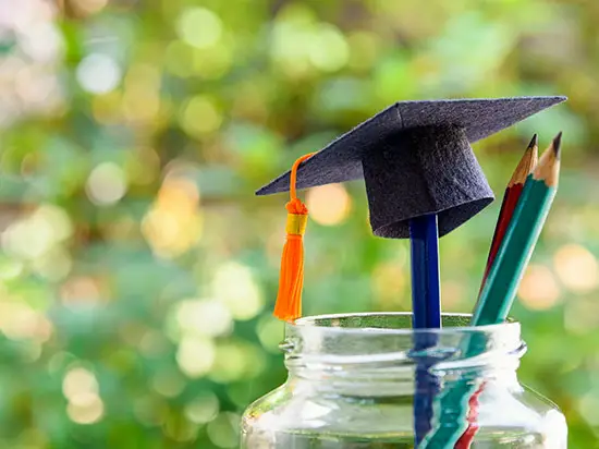 Image of graduation cap on top of a coin jar