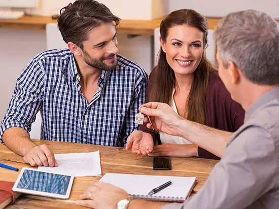 Image of couple receiving house keys from agent