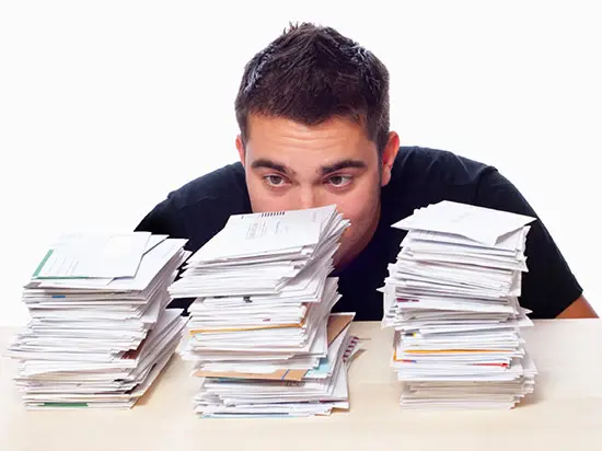 Image of man in front of stacks of bills
